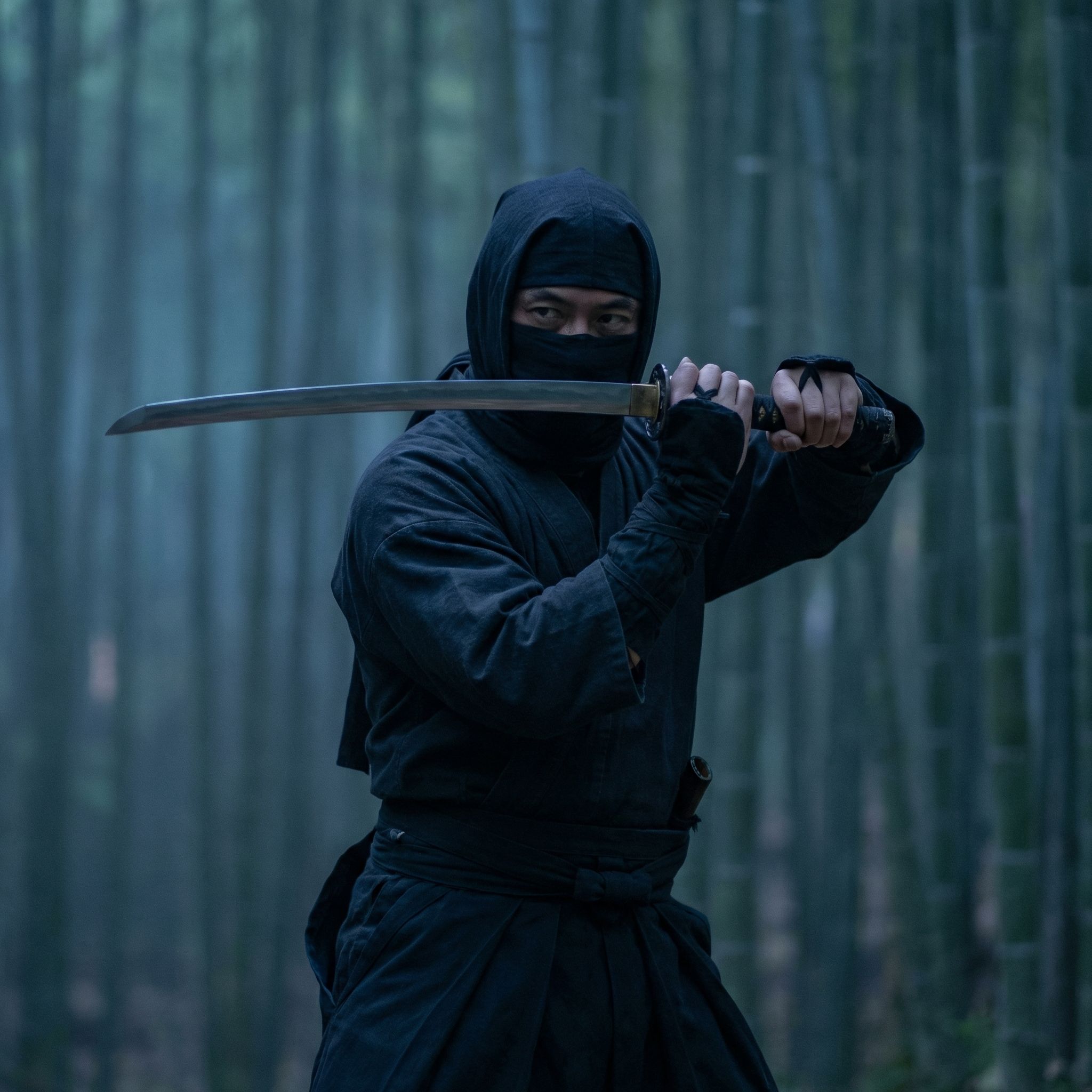 A Japanese ninja posing with katana sword.